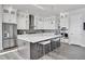 Modern kitchen with large island, stainless steel appliances, and white cabinets at 18352 W 95Th Pl, Arvada, CO 80007