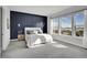 Spacious primary bedroom with a navy blue accent wall and large windows at 18352 W 95Th Pl, Arvada, CO 80007