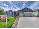 Two-story home with three car garage and manicured lawn at 18352 W 95Th Pl, Arvada, CO 80007