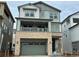 Two-story townhome with stone accents, two-car garage, and balcony at 8570 Eagle River St, Littleton, CO 80125