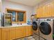 Bright laundry room with stacked washer and dryer, sink and cabinets at 29115 Summit Ranch Dr, Golden, CO 80401