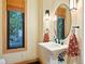 Elegant powder room with pedestal sink, oval mirror, and patterned towels at 29115 Summit Ranch Dr, Golden, CO 80401