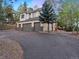 Three-car garage and paved driveway leading to a two-story house with mountain views at 29115 Summit Ranch Dr, Golden, CO 80401