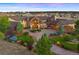 Luxury estate home with circular driveway, landscaping, and mountain views at dusk at 19155 Lochmere Ct, Monument, CO 80132