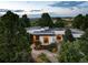 Modern home nestled amongst trees, showcasing architectural details and landscape at 3823 Castle Butte, Castle Rock, CO 80109