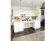 White kitchen with large island, breakfast bar, and dark hardwood floors at 3823 Castle Butte, Castle Rock, CO 80109