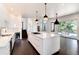 Modern kitchen with white cabinets, large island, and hardwood floors at 3823 Castle Butte, Castle Rock, CO 80109