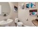 Powder room featuring a pedestal sink, toilet, and decorative wall art at 10916 Towerbridge Rd, Highlands Ranch, CO 80130