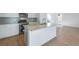 Modern kitchen with white cabinets, stainless steel appliances, and a large island at 13521 E 99Th Pl, Commerce City, CO 80022