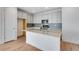 Modern kitchen with island, stainless steel appliances, and light cabinets at 13521 E 99Th Pl, Commerce City, CO 80022