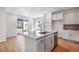 Eat-in kitchen features an island, sliding door to backyard, and light wood floors at 13521 E 99Th Pl, Commerce City, CO 80022