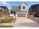 Two-story house with gray siding, a gray door, and a two-car garage at 13521 E 99Th Pl, Commerce City, CO 80022