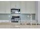 Modern kitchen with stainless steel appliances and backsplash at 13521 E 99Th Pl, Commerce City, CO 80022