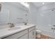 Modern bathroom with double vanity, white tile, and a bathtub at 13521 E 99Th Pl, Commerce City, CO 80022