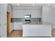 Modern kitchen with white cabinets, a large island, and light wood floors at 13521 E 99Th Pl, Commerce City, CO 80022