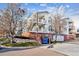 View of the exterior of a light-colored condo building with balconies and a dumpster in front at 1648 S Cole St # B7, Lakewood, CO 80228