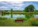 Serene park with a pond, bench, trees, and reflections of the sky at 1648 S Cole St # B7, Lakewood, CO 80228