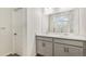 Modern bathroom with gray vanity, double sinks, and a glass shower at 9310 Bahama Ct, Commerce City, CO 80022