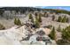 Aerial view of mountain property with dilapidated structures and surrounding trees at 131 Russel Gulch Rd, Central City, CO 80403