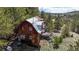 Rustic cabin nestled in the mountains with a deck and surrounding trees at 131 Russel Gulch Rd, Central City, CO 80403