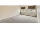 Simple bedroom with carpeted floors and two windows at 8731 Dawson St # 102, Denver, CO 80229