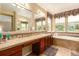 Elegant bathroom with double vanity, soaking tub, and tile flooring at 16628 E 106Th Dr, Commerce City, CO 80022