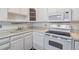 Kitchen with white cabinets, appliances, and tile floor at 495 S Dayton St # 10C, Denver, CO 80247