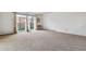 Bright living room with carpet flooring and sliding glass door to balcony at 495 S Dayton St # 10C, Denver, CO 80247
