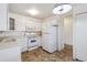 White kitchen features appliances and tile floor at 495 S Dayton St # 10C, Denver, CO 80247
