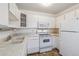 White kitchen with appliances and tile floor at 495 S Dayton St # 10C, Denver, CO 80247