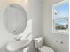 Bright bathroom boasts a pedestal sink and an oval mirror at 8683 Snake River St, Littleton, CO 80125