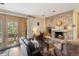 Cozy living room with stone fireplace and access to a deck overlooking trees at 1682 Montane E Dr, Golden, CO 80401