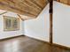Cozy bedroom with hardwood floors, wood beams, and forest views at 733 Rainbow Rd, Idaho Springs, CO 80452