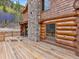 Log cabin with a wooden deck and mountain backdrop at 733 Rainbow Rd, Idaho Springs, CO 80452