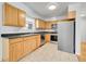 Kitchen with wood cabinets, stainless steel appliances, and dark countertops at 1431 Tamarac St, Denver, CO 80220