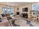 Living room with L-shaped sofa, fireplace, and sliding glass doors to backyard at 8901 S Ukraine Ct, Aurora, CO 80016