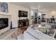 Open concept living room with fireplace, large TV, and hardwood floors at 8901 S Ukraine Ct, Aurora, CO 80016