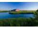 Picturesque community lake with a red barn in the background at 10994 Norfolk Ct, Commerce City, CO 80022