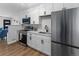 Updated kitchen with white cabinets and stainless steel appliances at 1100 S Quitman St, Denver, CO 80219