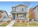 Two-story house with gray siding, front porch, and landscaping at 6570 N Ceylon St, Denver, CO 80249