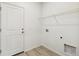 Bright laundry room with built-in shelving and vinyl flooring at 9280 Bahama Ct, Commerce City, CO 80022