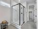 Large walk-in shower with marble tile and frameless glass door at 13351 E 100Th Pl, Commerce City, CO 80022