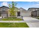 Two-story home with gray siding, a front porch, and a two-car garage at 13351 E 100Th Pl, Commerce City, CO 80022