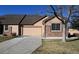 Tan two-story home with a two-car garage and landscaped yard at 6475 Orion Way, Arvada, CO 80007