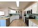 Modern kitchen with white cabinets, light countertops, and stainless steel appliances at 6475 Orion Way, Arvada, CO 80007