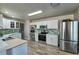 Modern kitchen with white cabinets, light countertops, and stainless steel appliances at 6475 Orion Way, Arvada, CO 80007