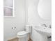 Clean and bright half bathroom with pedestal sink and updated toilet at 3051 Newfound Lake Rd, Berthoud, CO 80513