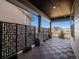 Covered patio with patterned tile flooring, modern screen, and comfortable seating area at 3051 Newfound Lake Rd, Berthoud, CO 80513