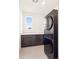 Laundry room with modern washer and dryer, and dark wood cabinets at 3051 Newfound Lake Rd, Berthoud, CO 80513