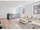 Open living area with L-shaped sectional sofa and hardwood floors at 3051 Newfound Lake Rd, Berthoud, CO 80513